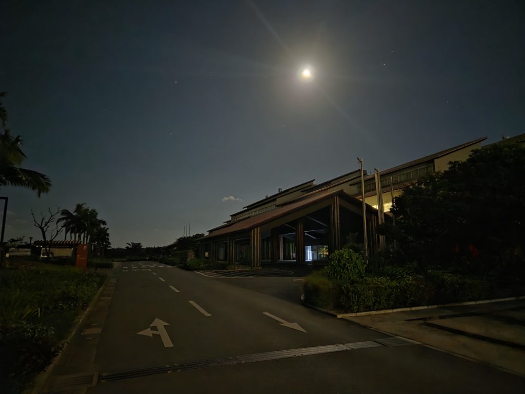 夜の輝く月が背景の石垣島の市役所の写真